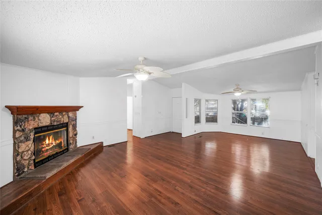 an empty room with windows and fireplace