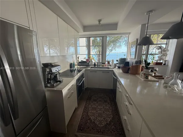 a kitchen that has a sink stainless steel appliances a window and a counter top space