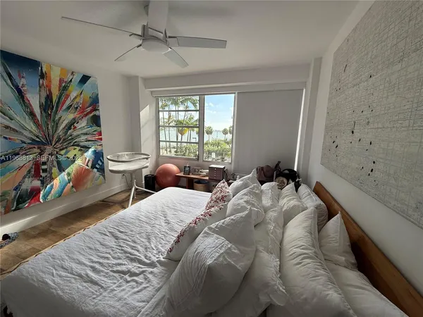 a bedroom with bed and a large window