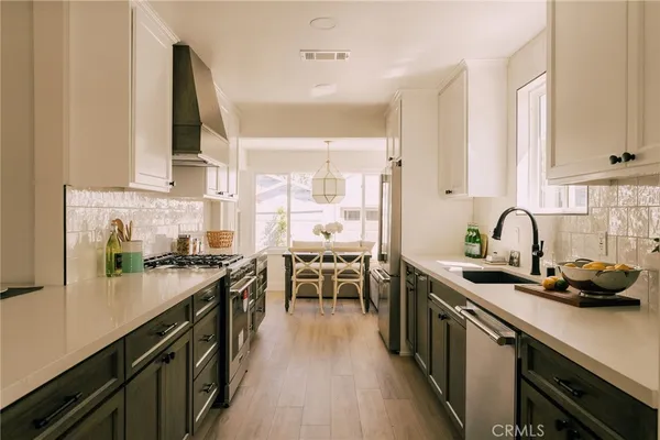 a kitchen with kitchen island a sink appliances cabinets and a counter top space