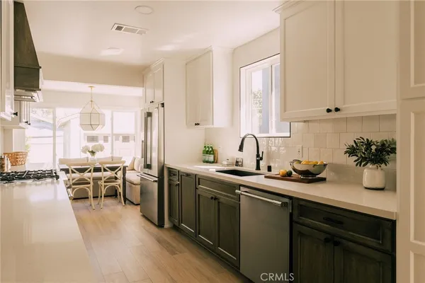 a kitchen with lots of counter top space a sink appliances and cabinets