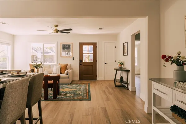 a living room with furniture two window and wooden floor