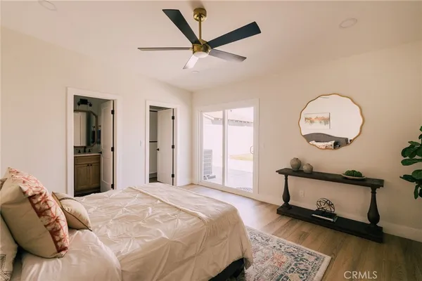 a bedroom with a bed a mirror and a window