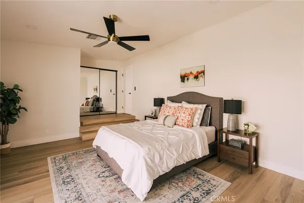 a bedroom with bed and wooden floor