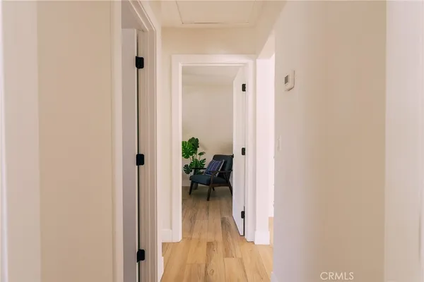a view of a hallway with dining room and wooden floor