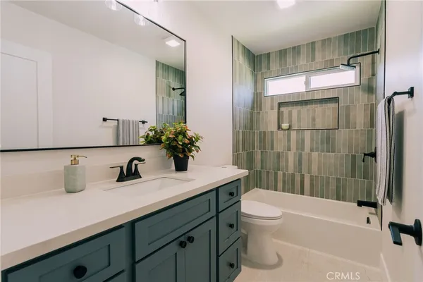 a bathroom with a sink a toilet and a large mirror