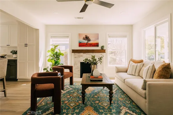 a living room with furniture a fireplace and a window