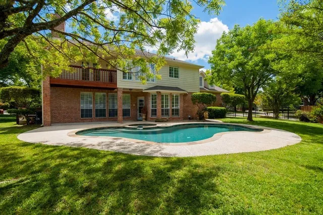 a view of a house with a big yard plants and large trees