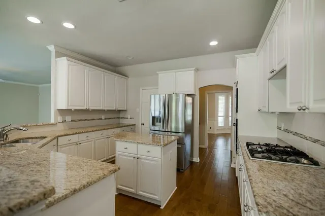 a kitchen with stainless steel appliances granite countertop a sink stove and refrigerator