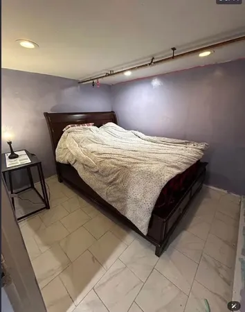 a bedroom with a bed and a lamp on the dresser