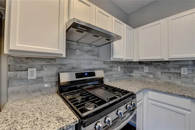 a kitchen with wooden cabinets and a stove top oven