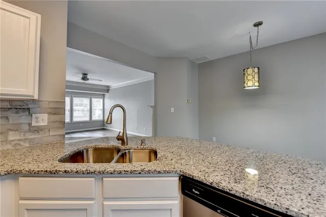 a kitchen with granite countertop a sink and chandelier
