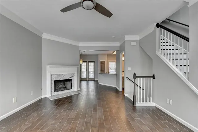 a view of a livingroom with wooden floor a fireplace and windows