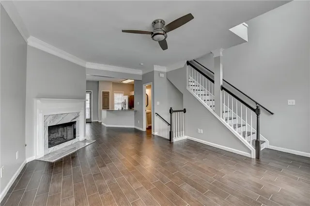 a view of an empty room with wooden floor a fireplace and a window