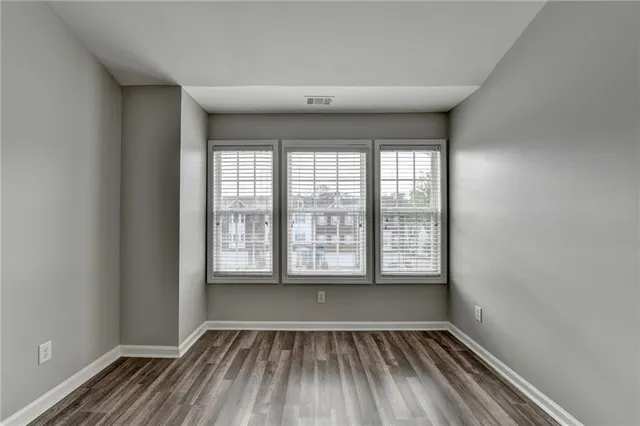 a view of empty room with wooden floor