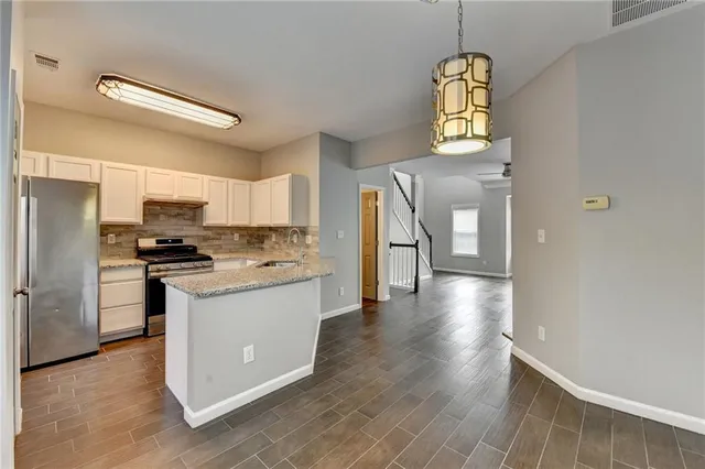 a kitchen with stainless steel appliances granite countertop a refrigerator a stove top oven a sink and dishwasher