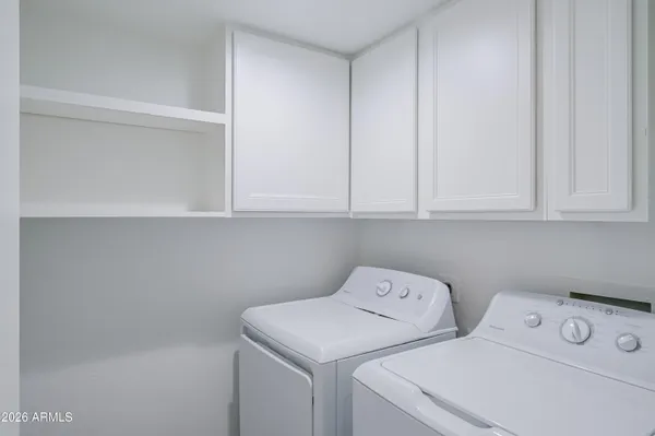 an empty room with wooden floor and fan