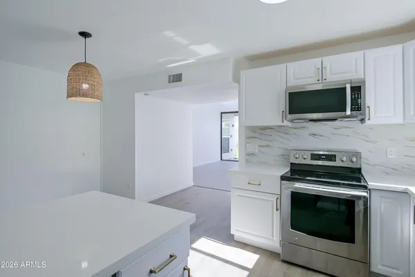 a kitchen with granite countertop a stove and a microwave