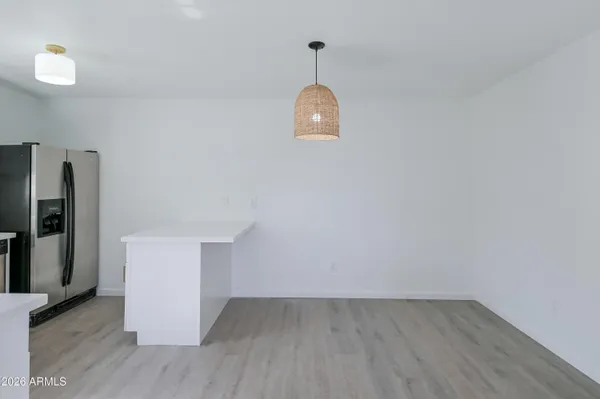 a view of empty room with wooden floor and window