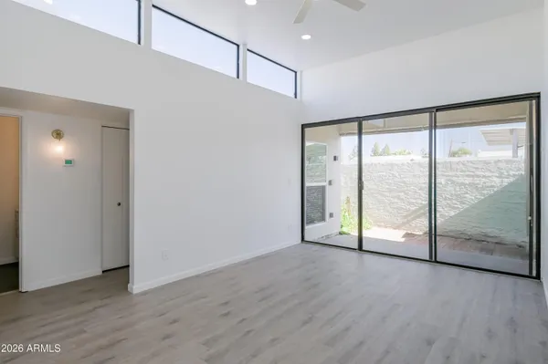 a view of an empty room with wooden floor and sliding door
