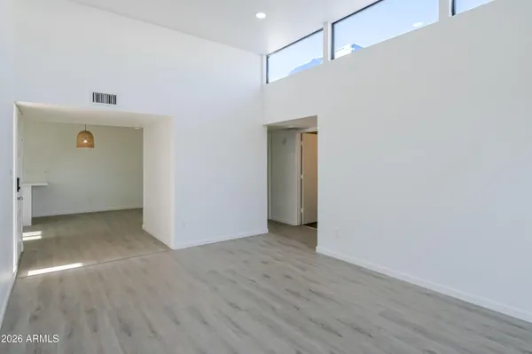 a view of an empty room with wooden floor and sliding door