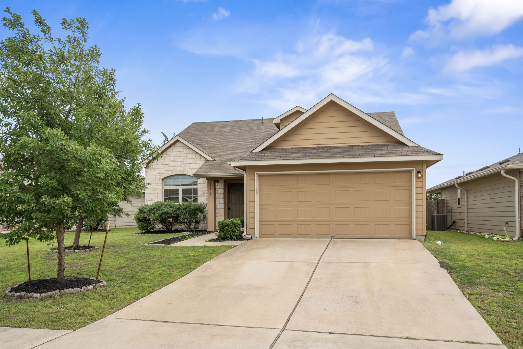 Exterior featuring a two-car garage, stone and siding facade, and a concrete driveway