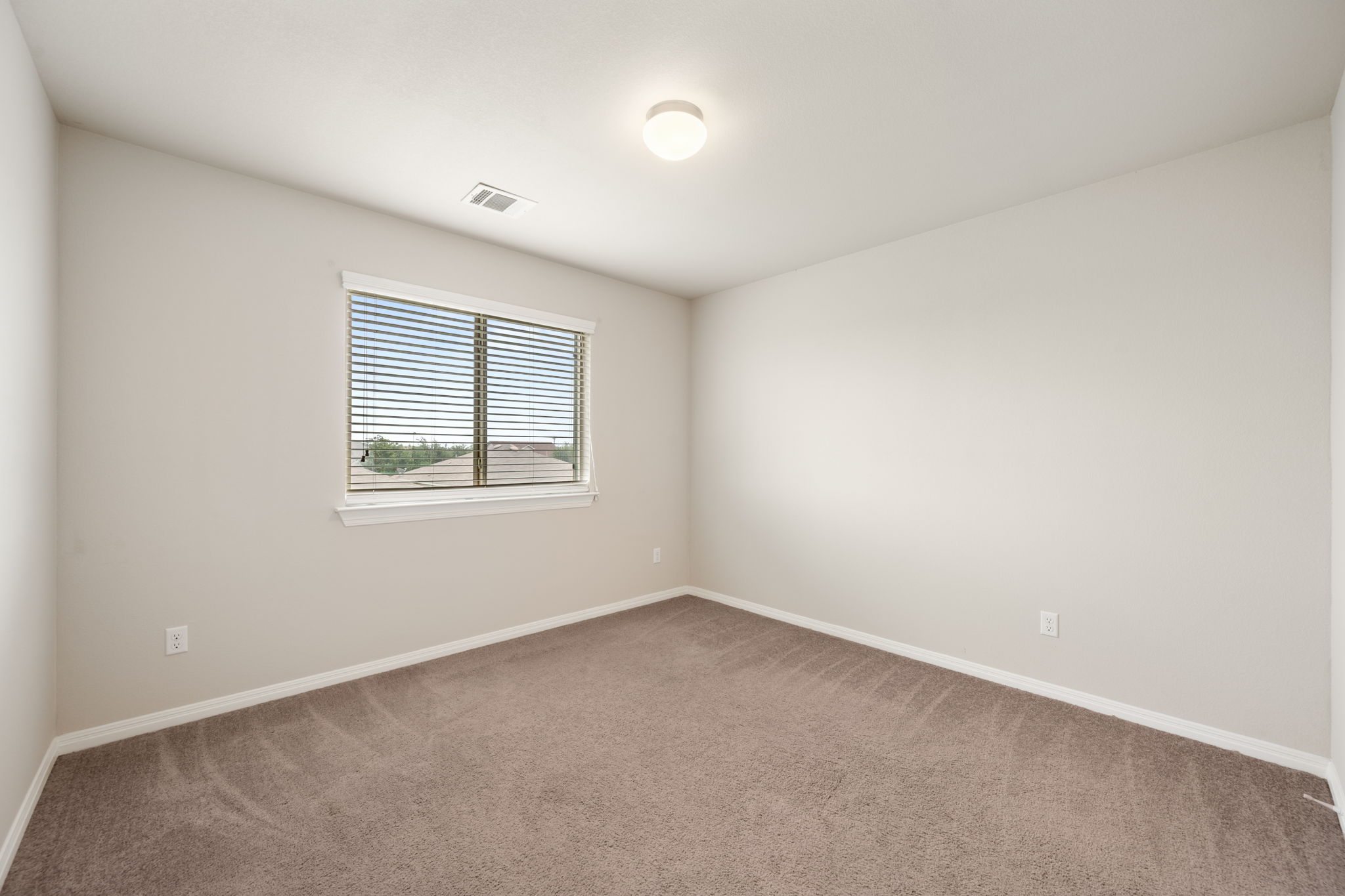 12701 Carillon Way Manor, TX 78653 - Photo 17 of 20 Neutral-toned walls complement the brown carpeted flooring