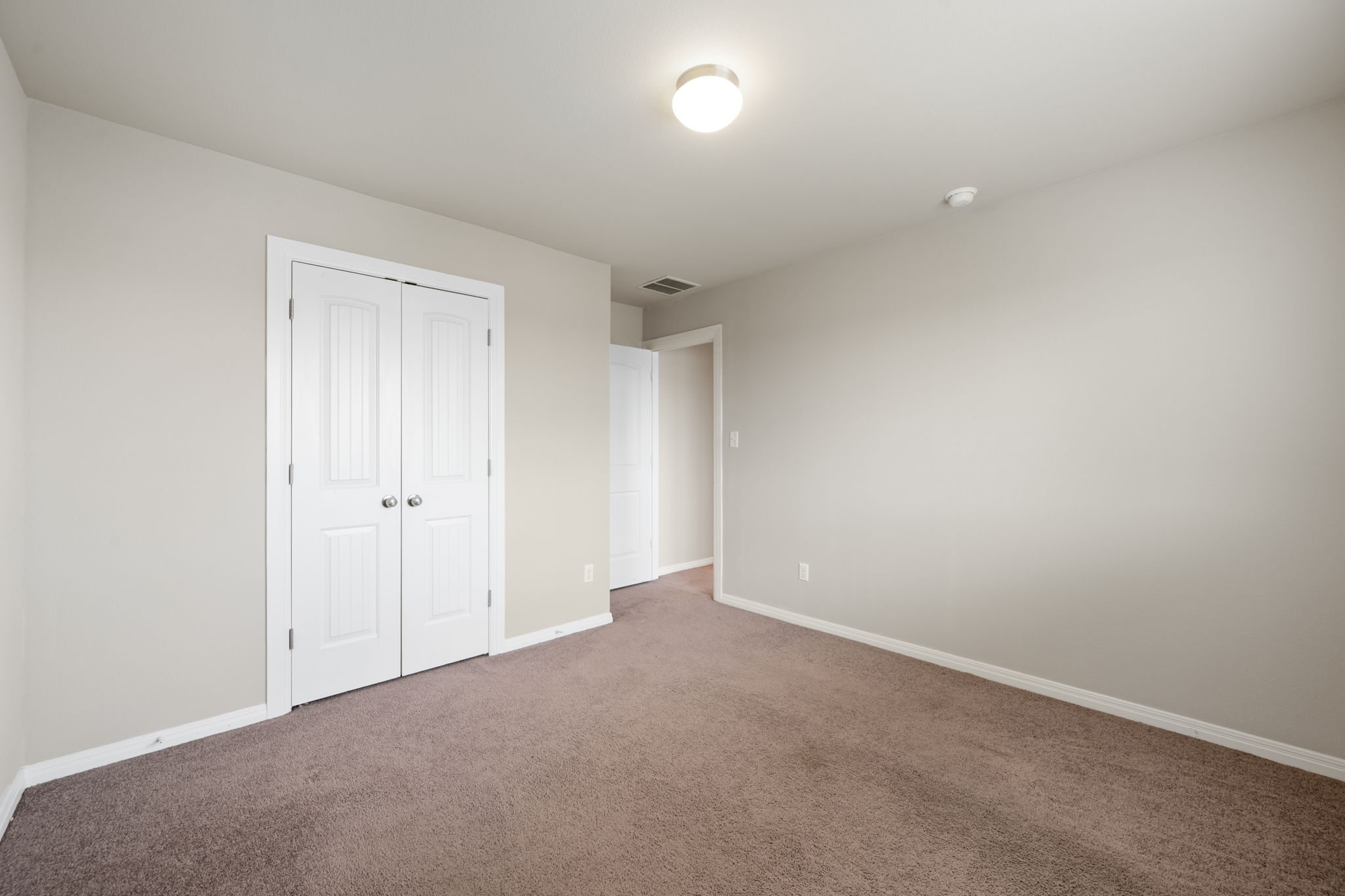 12701 Carillon Way Manor, TX 78653 - Photo 18 of 20 Neutral-toned room featuring a flush-mount ceiling light, white trim, and brown carpeting
