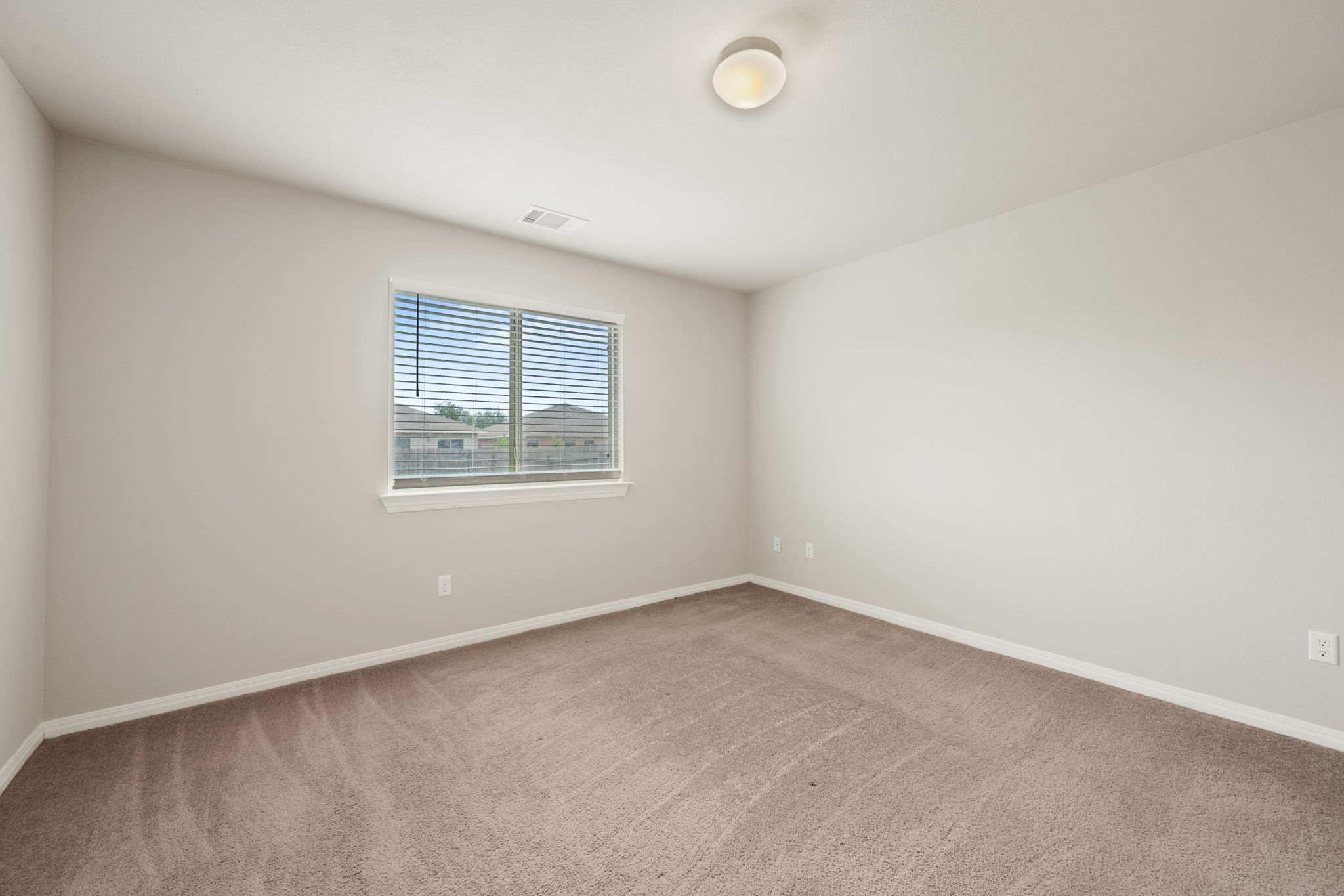 12701 Carillon Way Manor, TX 78653 - Photo 7 of 20 Carpeted room featuring a single window with blinds, white trim, and a flush-mount ceiling light fixture