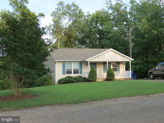 12622 Hilltop Road Lusby, MD 20657 - Photo 1 of 23 a front view of a house with a garden