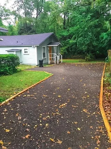 a view of a house with backyard and a tree
