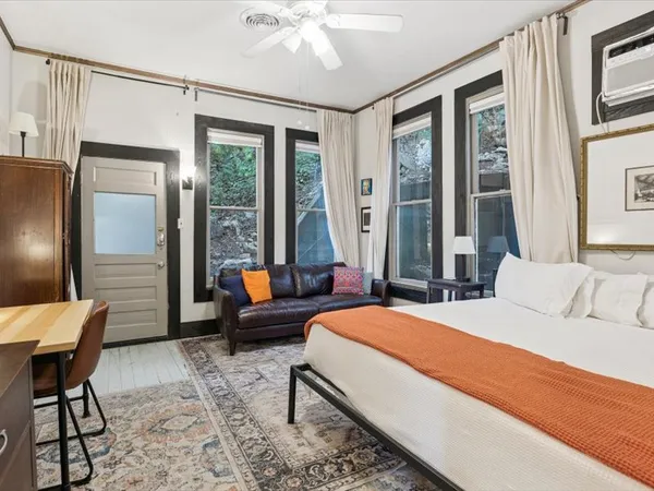 a bedroom with a bed large window and couch