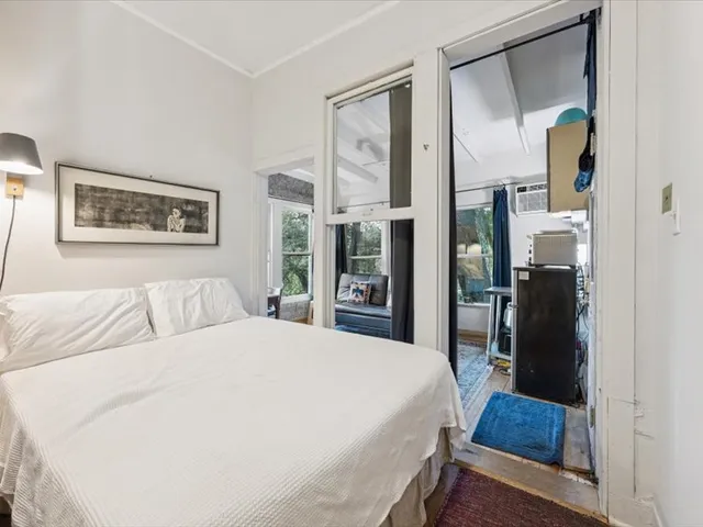 a bedroom with a bed and a large mirror