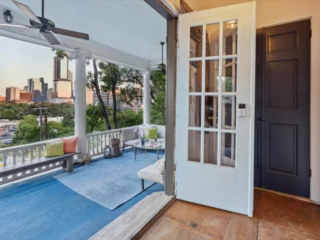 a view of an empty room with wooden floor and windows