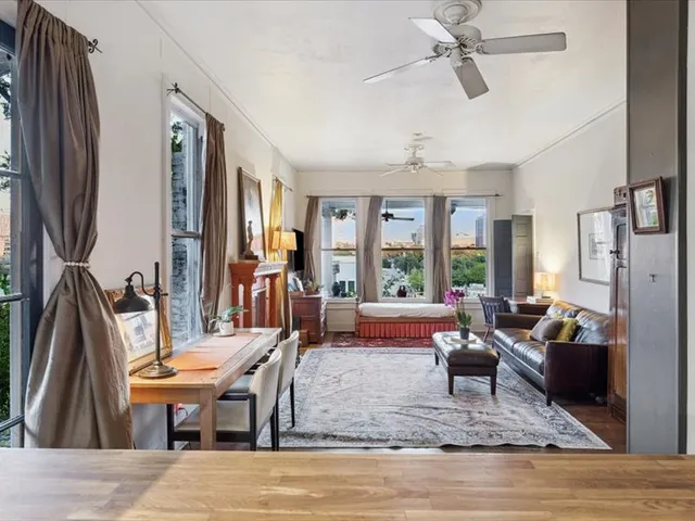 a living room with furniture fireplace and a large window