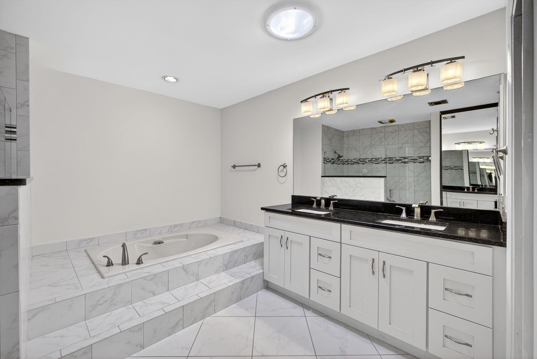 141 Cape Pointe Circle Jupiter, FL 33477 - Photo 14 of 31 a spacious bathroom with a granite countertop sink mirror and bathtub