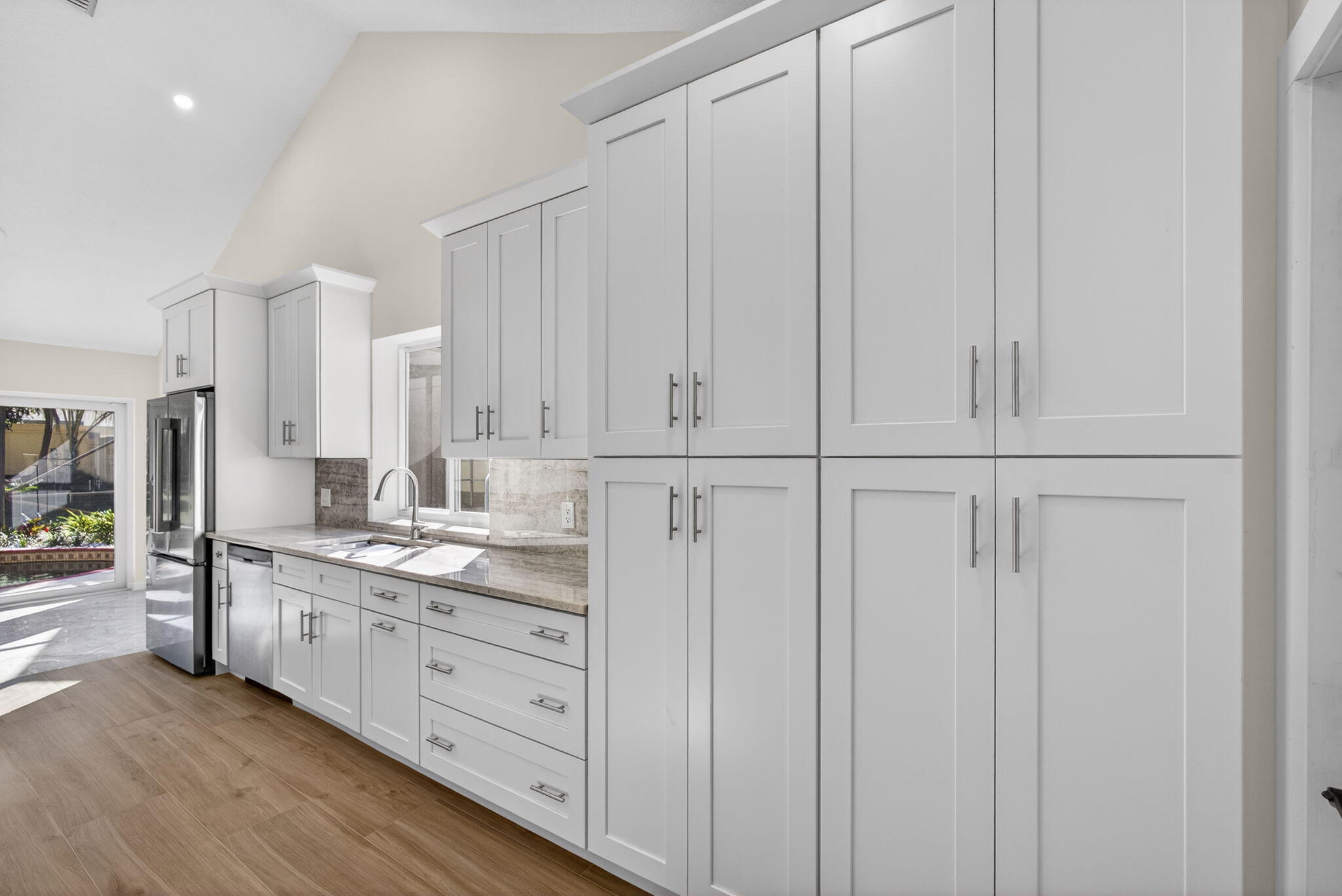 141 Cape Pointe Circle Jupiter, FL 33477 - Photo 6 of 31 a kitchen with white cabinets and sink