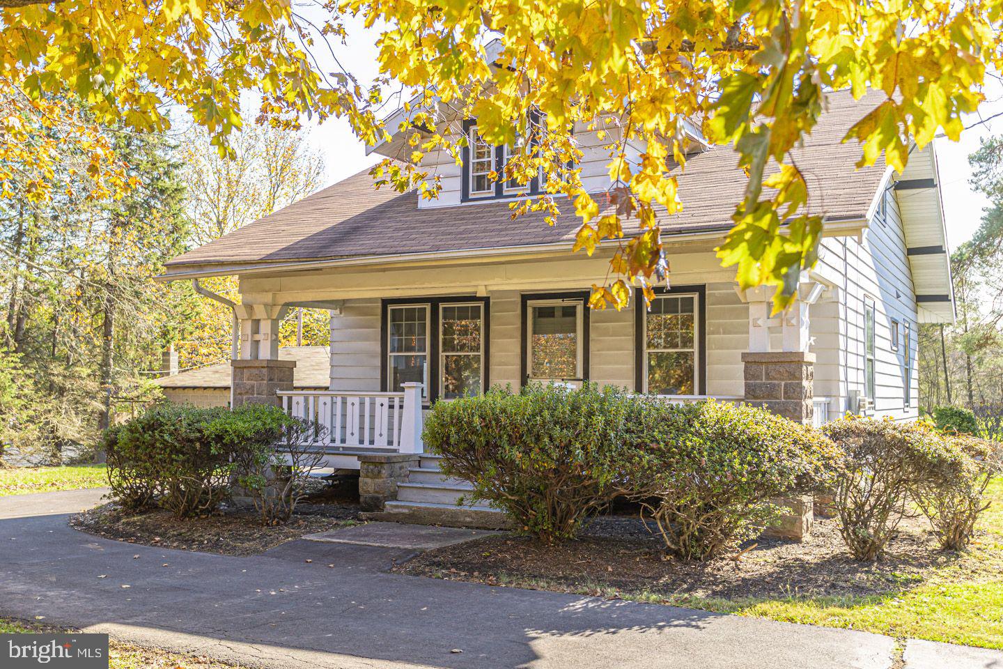 1525 Yardley Newtown Road Yardley, PA 19067 - Photo 1 of 15 a view of a brick house with large windows and a table and chairs