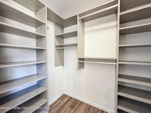 a view of walk in closet with empty racks