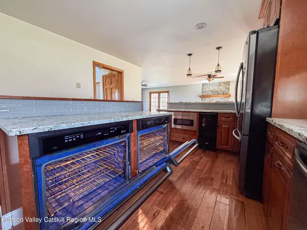 a kitchen with stainless steel appliances granite countertop a stove a refrigerator and wooden floors