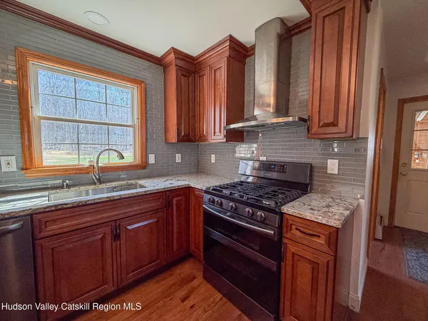a kitchen with stainless steel appliances granite countertop a stove a sink and a microwave