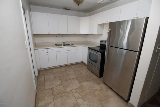 a kitchen with stainless steel appliances granite countertop a refrigerator and a sink