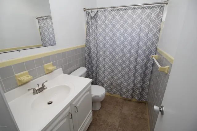 a bathroom with a sink a toilet and shower curtain