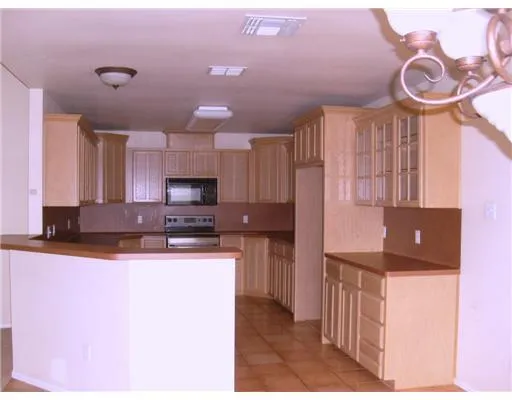a kitchen with kitchen island granite countertop a sink cabinets and stainless steel appliances