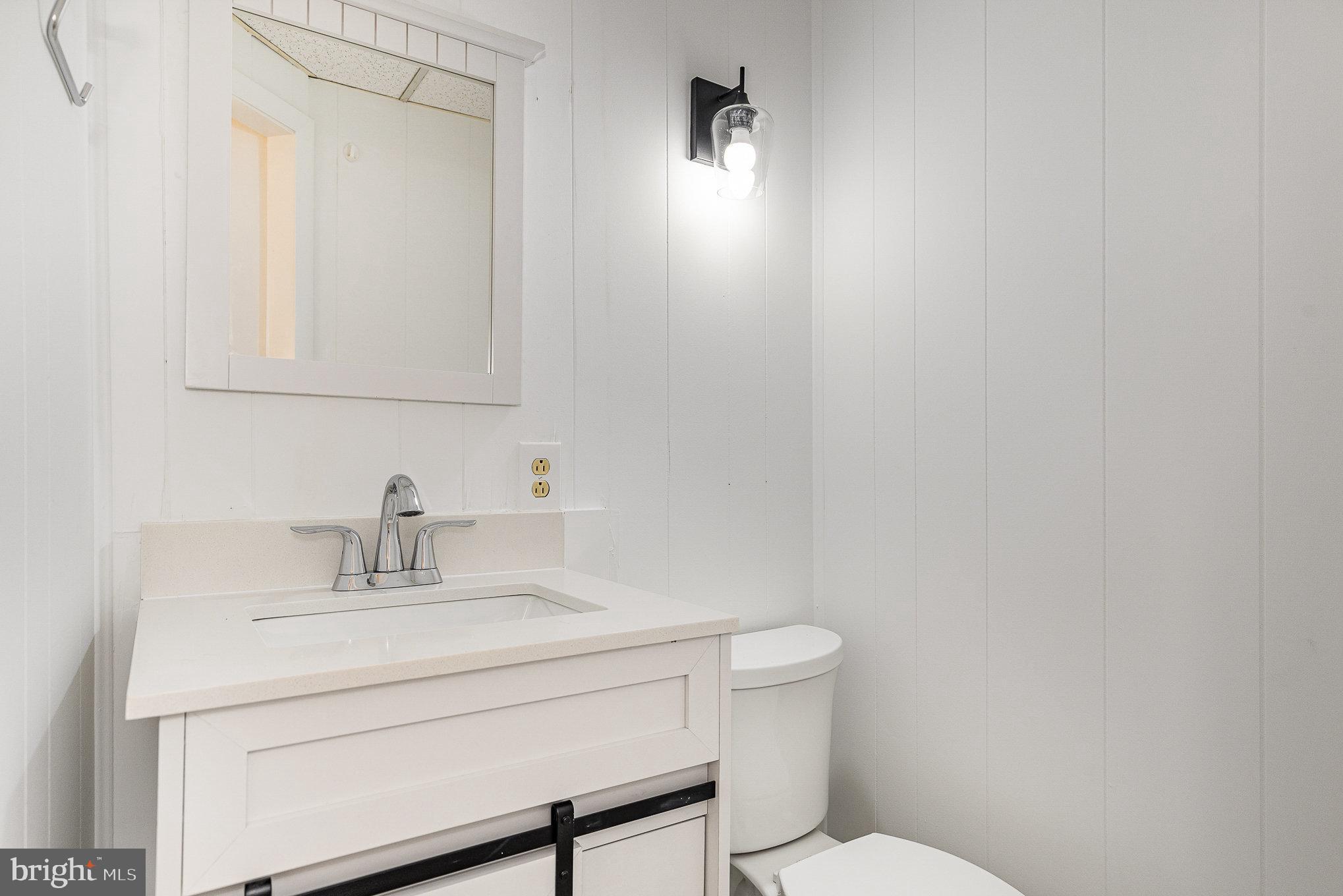 6908 South Roxbury Mill Road Spotsylvania, VA 22551 - Photo 52 of 92 a bathroom with a toilet a sink and mirror