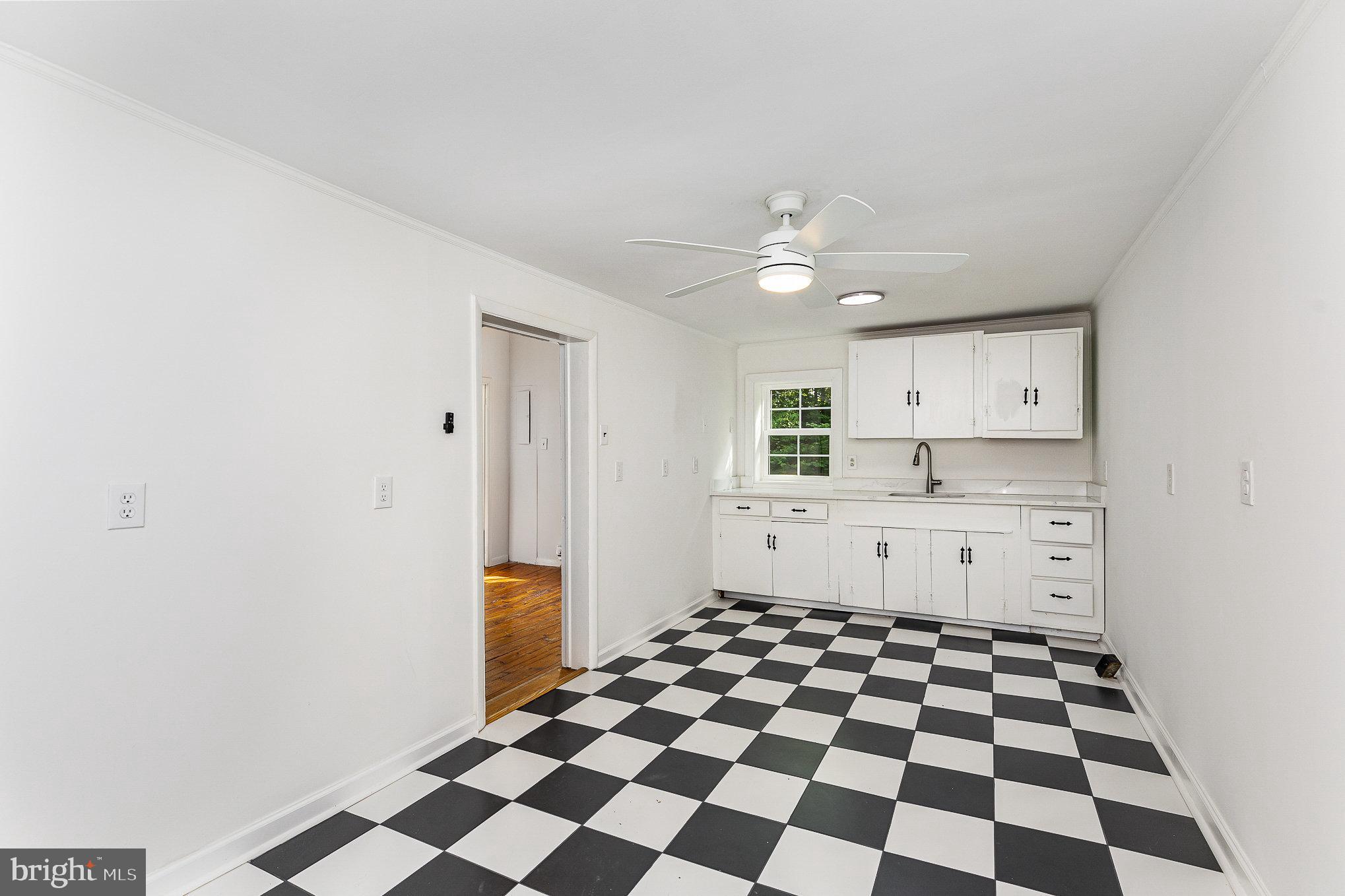 6908 South Roxbury Mill Road Spotsylvania, VA 22551 - Photo 76 of 92 a kitchen with a sink a refrigerator and white cabinets