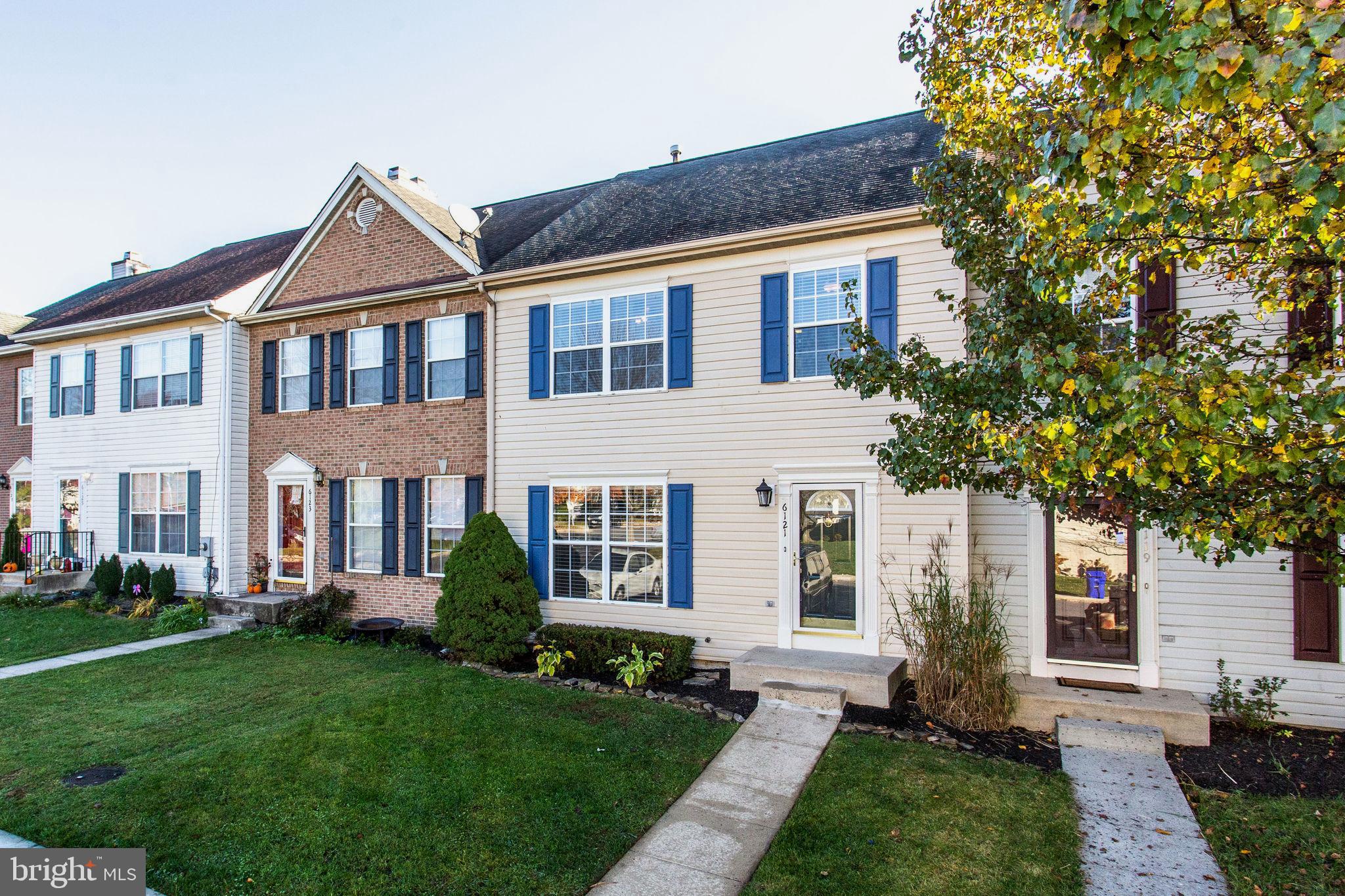 a front view of a house with a yard and trees