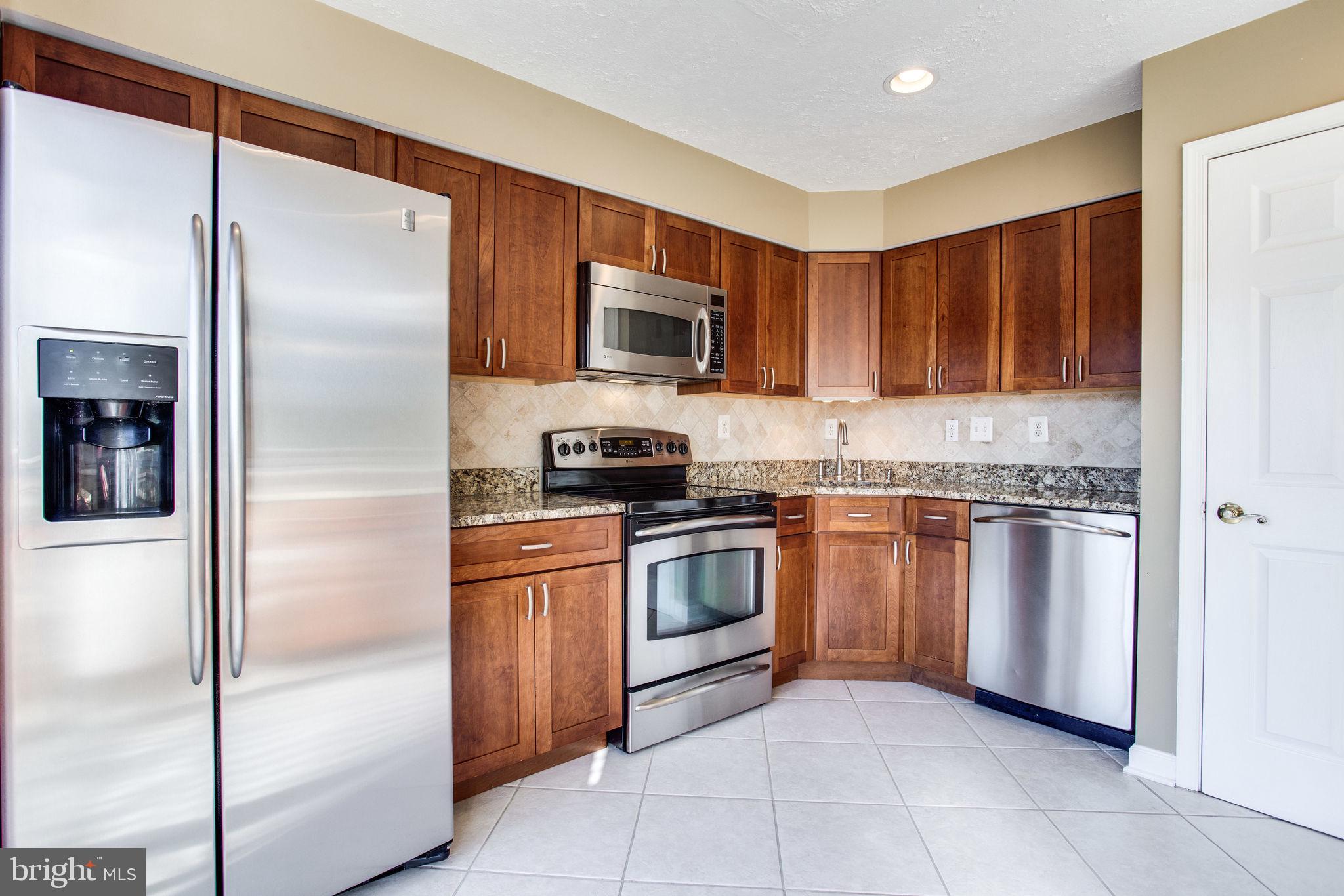 6121 Baldridge Circle Frederick, MD 21701 - Photo 10 of 60 a kitchen with stainless steel appliances granite countertop a refrigerator and a stove top oven