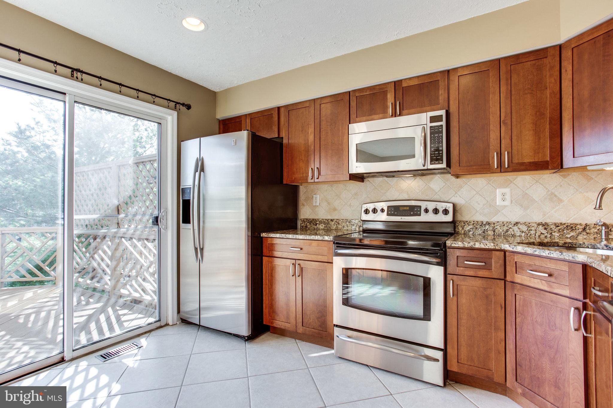 6121 Baldridge Circle Frederick, MD 21701 - Photo 11 of 60 a kitchen with granite countertop a refrigerator and a stove top oven