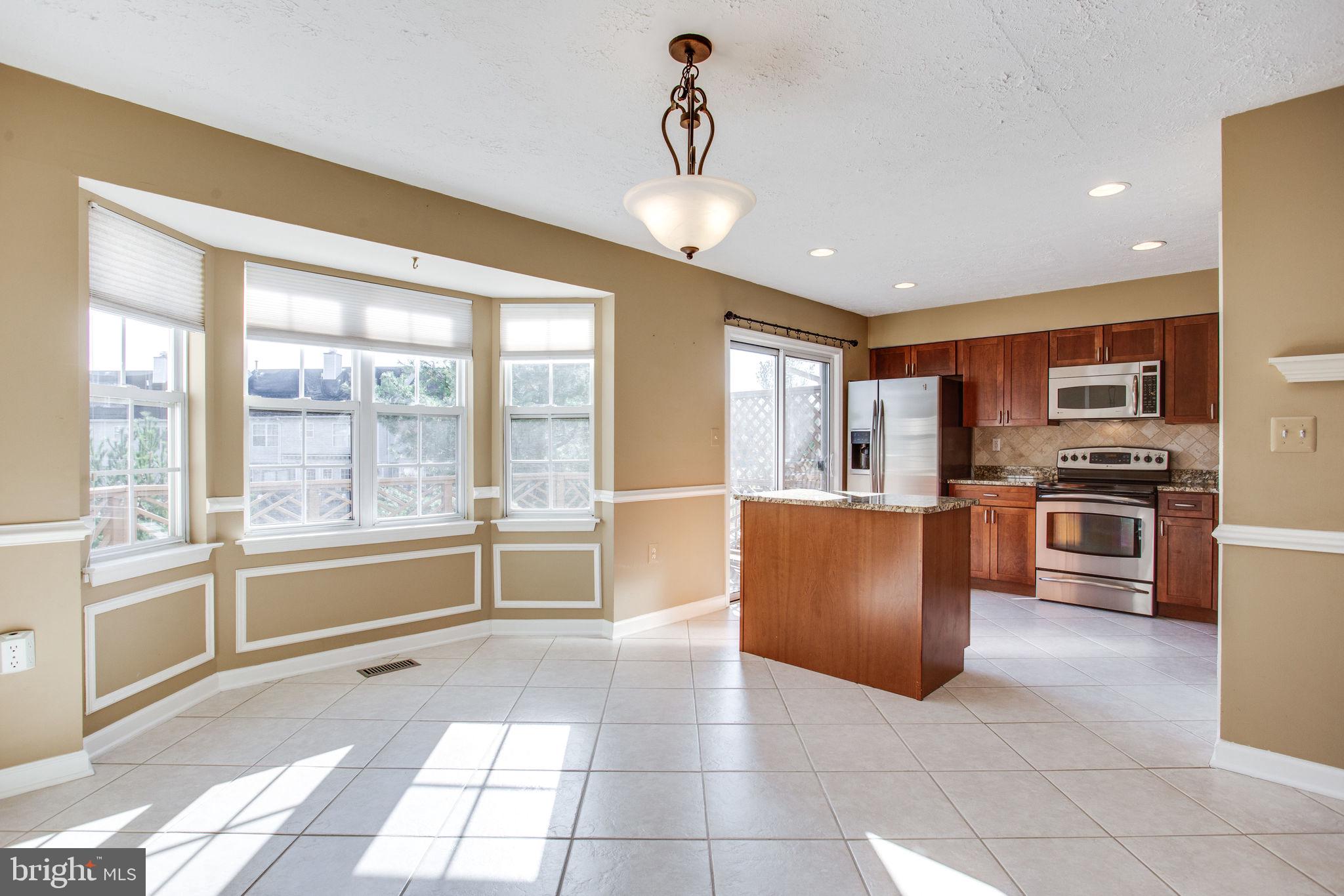 6121 Baldridge Circle Frederick, MD 21701 - Photo 13 of 60 a large kitchen with kitchen island granite countertop a large window and stainless steel appliances